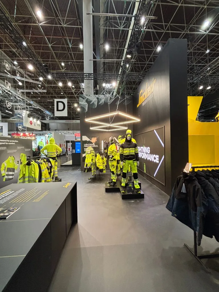 Dark exhibition stand with spotlighting for the Snickers Hi-Vis collection, built by Wilzéns Expo