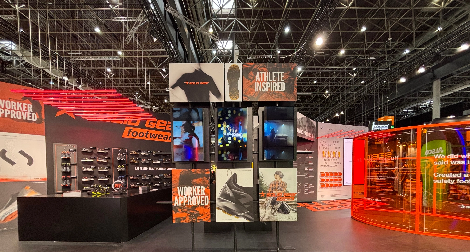 Solid Gear exhibition stand with footwear display, image wall and orange glass volume, built by Wilzéns Expo