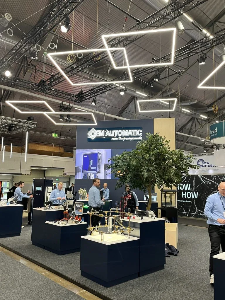 OEM Automatics mässmonter med geometrisk ljusrigg och demobord, byggd av Wilzéns Expo
